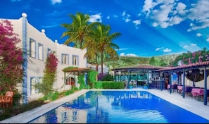 Una piscina al aire libre, sillones reclinables de piscina