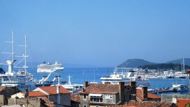 A harbor with multiple boats and ships, including a large cruise ship, and buildings with red-tiled roofs. - Apartment near centar-view to port from apartment (Split)