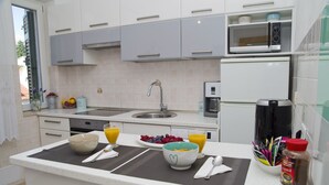 A modern kitchen with white cabinets, a microwave, a coffee maker, and a fruit bowl. - Apartment near centar-view to port from apartment (Split)