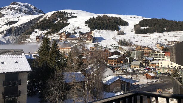 A mountain town with snow-covered buildings and a clear blue sky.