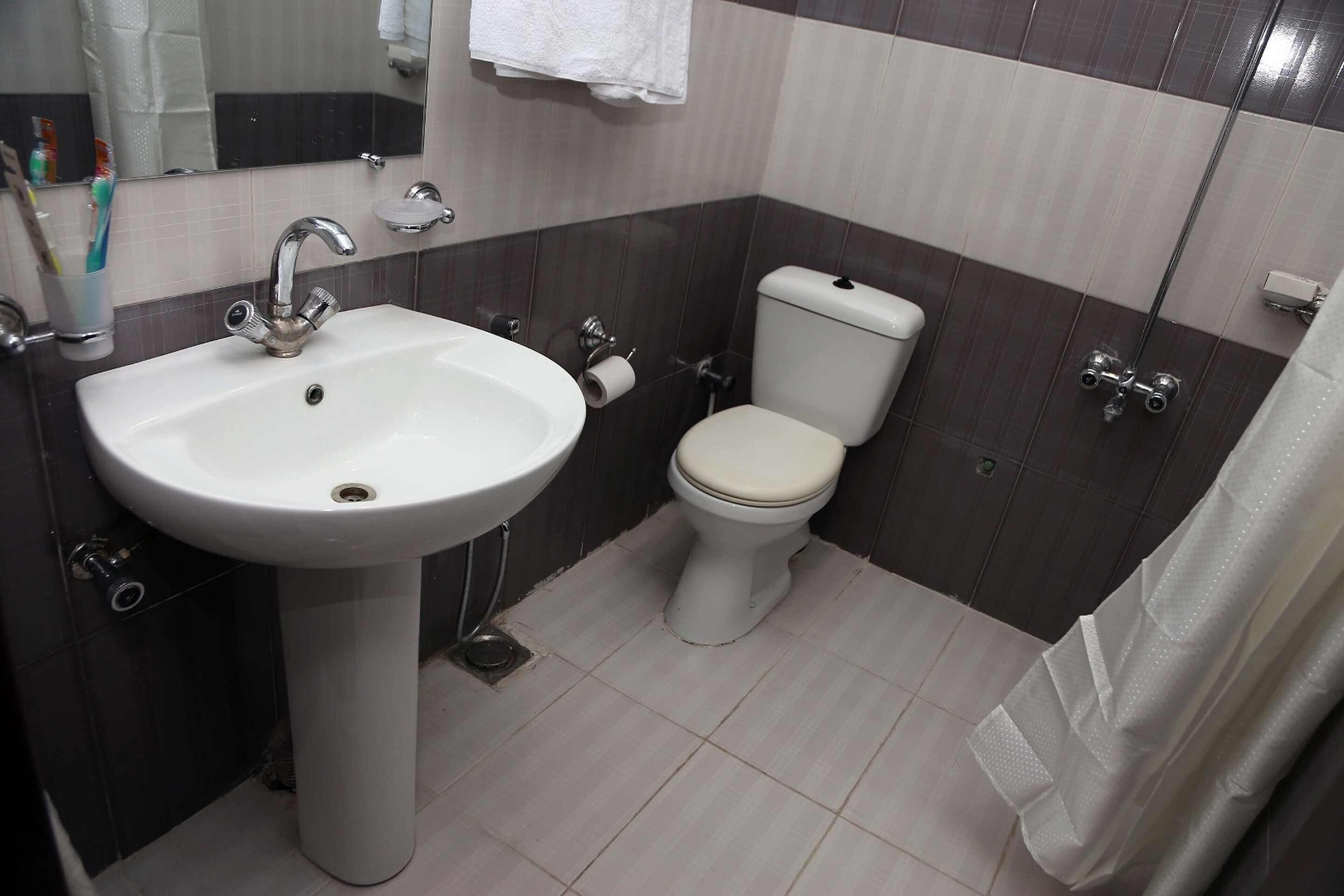 A bathroom with a white sink, toilet, and shower.