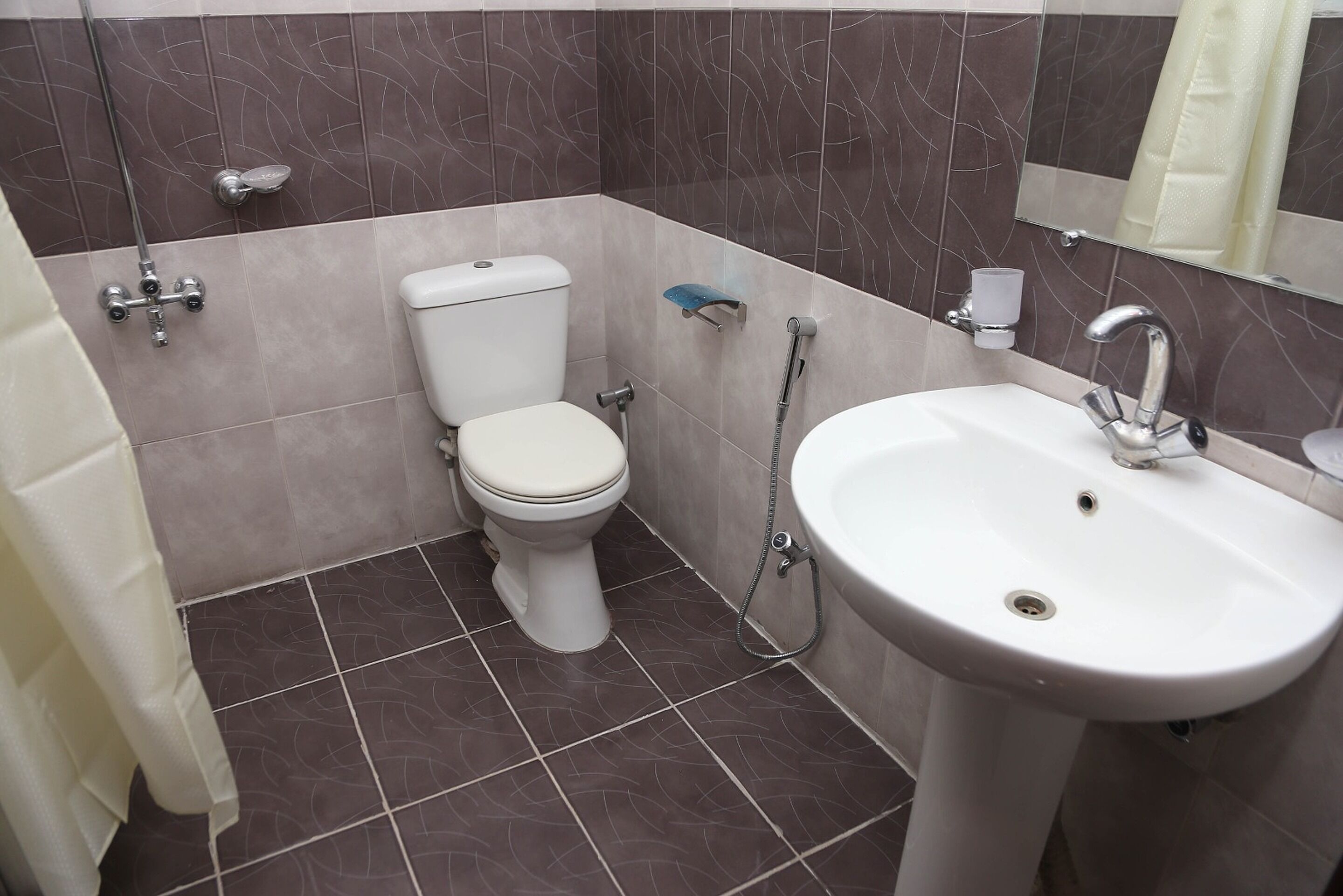 A bathroom with a toilet, sink, and shower.