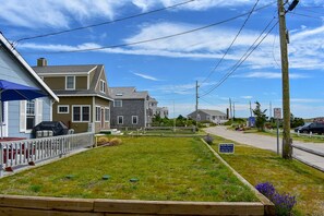 A residential street with houses, a grassy lawn, and a sign for Marquette Manor.