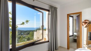 Een slaapkamer met een groot raam dat uitzicht biedt op een bergachtig landschap.