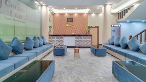A hotel lobby with a reception desk, seating area, and a staircase. - Hotel Golden Leaf Kashmir (Srinagar)