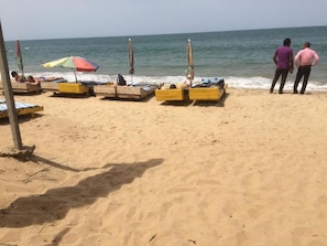 Na praia, areia branca, espreguiçadeiras