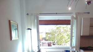 Een woonkamer met een bank, een salontafel en uitzicht op buiten.