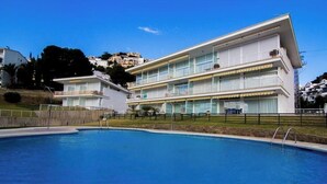 A modern hotel with a pool, multiple balconies, and a view of the surrounding area. - Agi Almadraba 2212 Apartamento for rent in Roses Girona. (Roses)