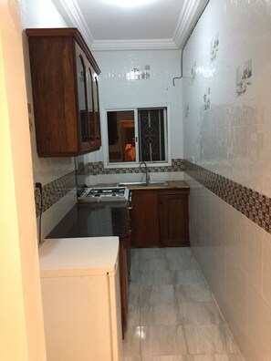 Een koelkast, kookgerei, borden en bestek