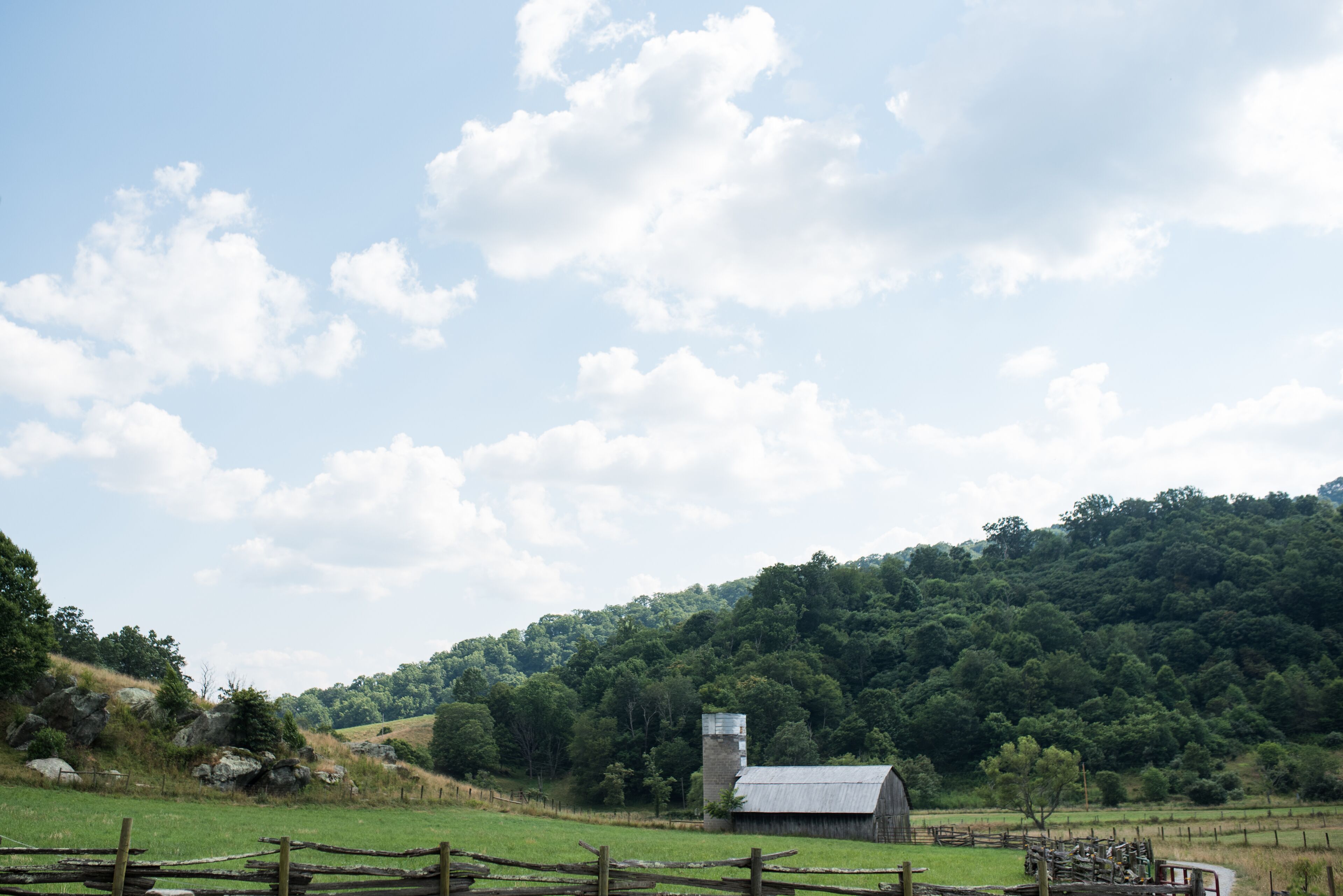 Un paysage rural avec une grange et une tour à grain sur une colline.