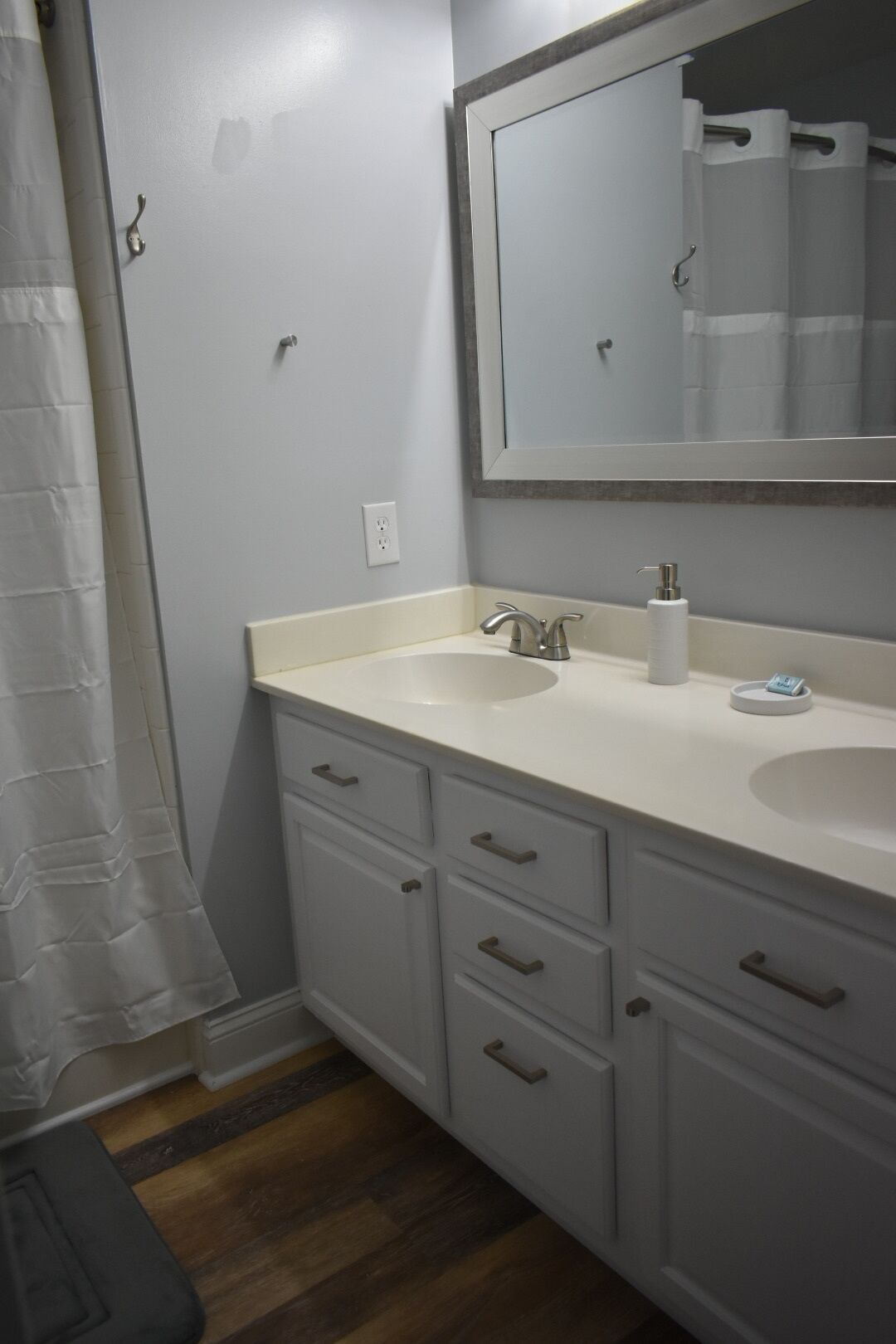 A bathroom with two sinks, a large mirror, and a shower curtain.