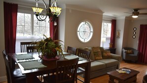 A dining area with a table set for four, a sofa, and a coffee table. - Special Pricing Uptown Condo Minutes from Bank of America Stadium (Charlotte)