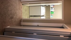 Una habitación con tragaluces, lavadora y secadora integradas y un ventanal pequeño.