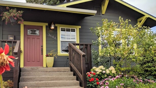 A house with a yellow front door, a number '364' on the wall, and a staircase leading to the entrance. - Dragonfly House-One Bedroom Craftsman in Trendy Kenton (Portland)