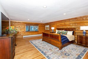 A log cabin bedroom with a wooden bed, a nightstand, a dresser, and a window with blinds. - High End Keystone Resort Home, Close to Skiing, Lake Dillon, Family Friendly (Keystone)