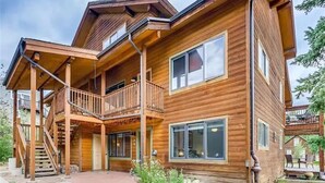 A two-story wooden cabin with a balcony, large windows, and a covered porch. - Mountain Comfortable Colorado Lodging in Frisco CO - Sleeps 8 - 1 block off Main (Frisco)