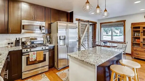 A modern kitchen with granite countertops, stainless steel appliances, and wooden cabinets. - Mountain Comfortable Colorado Lodging in Frisco CO - Sleeps 8 - 1 block off Main (Frisco)