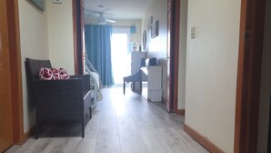 A hallway with a wicker sofa, a desk, a lamp, and a sign on the wall. - Oceanfront 3 Bedroom 3 Full Bath Townhome With Panoramic Views Of The Ocean  (Seaside Park)