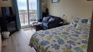 A hotel room with a bed, a sofa, a TV, a desk, and a balcony with a view. - Oceanfront 3 Bedroom 3 Full Bath Townhome With Panoramic Views Of The Ocean  (Seaside Park)