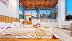 Une chambre d’hôtel avec un grand lit, une baignoire et un téléviseur.