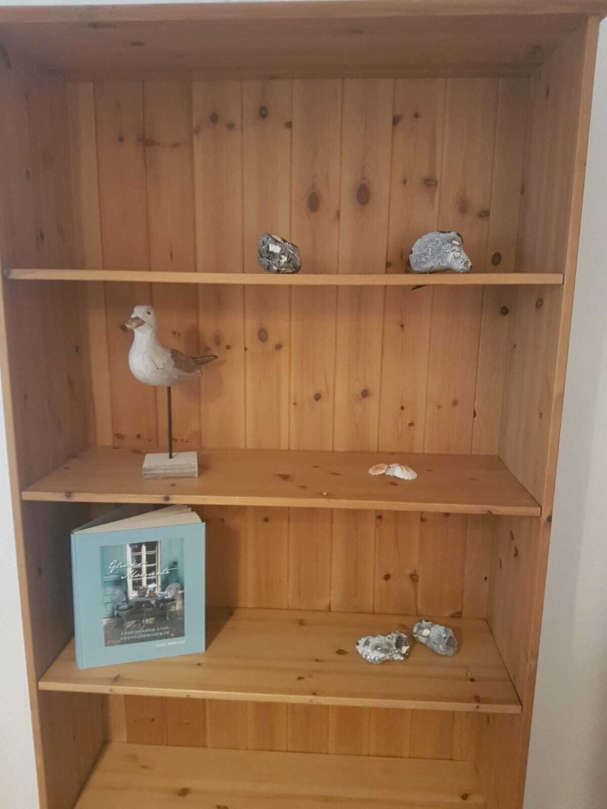 Un ripiano in legno con tre mensole, ognuna con diversi oggetti.
