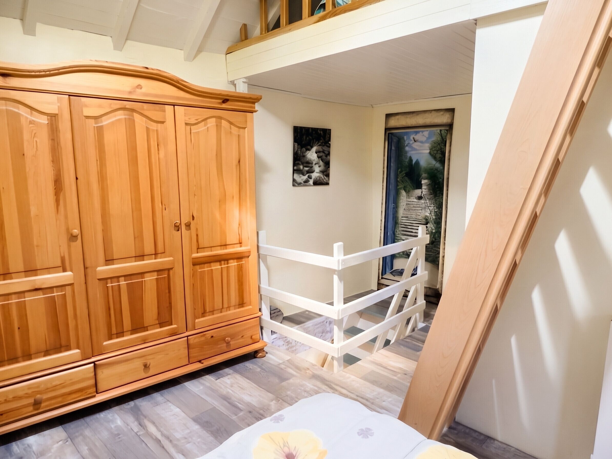 Un dormitorio con un armario de madera, una cama blanca y vista a un jardín a través de una puerta.