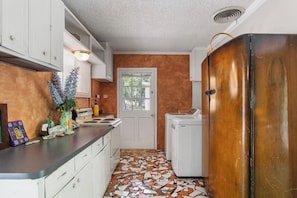 A kitchen with a tiled floor, a stove, a sink, and a refrigerator. - Casa del Rio | Pet-Friendly River Stay with Views (Bandera)