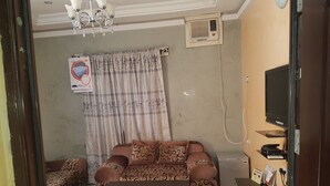 Ein Wohnzimmer mit einer Couch, einem Couchtisch, einem Fernseher und einem Telefon.