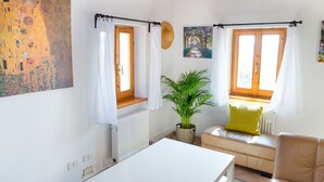 A cozy living room with a sofa, a table, and a potted plant. - Home set in Olive Grove With Stunning Views (Mondavio)