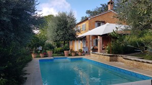 A pool with a tiled edge, surrounded by greenery and a brick house with a tiled roof. - Home set in Olive Grove With Stunning Views (Mondavio)