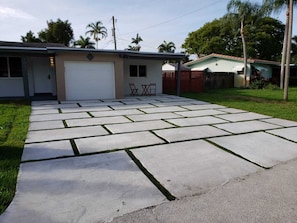 A residential garage with a concrete driveway leading to a house.
