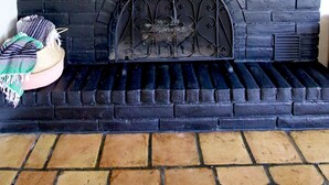 A fireplace with a black brick surround, a decorative skull, and a mirror above it. - Spacious lakefront home with dock - perfect for a group getaway (Lago Vista)