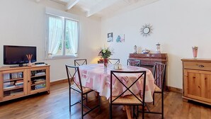 A dining area with a table, chairs, a TV, and a bookshelf. - Wonderful private villa for 4 people with WIFI, TV and pets allowed (Lanros)