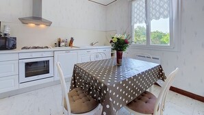 A compact kitchen with a dining area, white cabinetry, a stove, and a window with a view. - Wonderful private villa for 4 people with WIFI, TV and pets allowed (Lanros)