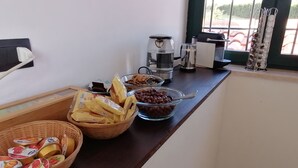 A breakfast buffet setup with various food items and a coffee maker on a counter. - Le Vecchie Scuderie (Fara in Sabina)