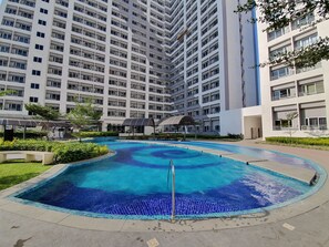 Edificio residencial con piscina, destacando un diseño de mosaico azul.