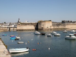 Stroll along the historic harbor, surrounded by moored boats and a picturesque clock tower.