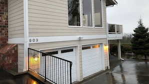 A two-story house with a garage, a balcony, and a brick foundation.