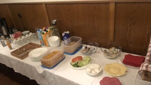 A buffet table with various food items and containers. - Hotel Holthausen (Uebach-Palenberg)