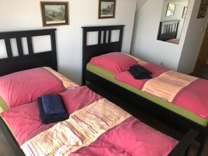 A room with two beds, each with a headboard and pillows. There are framed pictures on the wall. - Hotel Holthausen (Uebach-Palenberg)