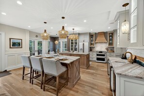 A spacious kitchen with wooden cabinets, a central island, and pendant lighting. - Spacious Luxury Home! Private POOL and GOLF Course Views! (Kiawah Island)