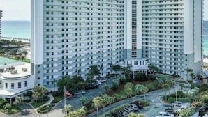 A high-rise hotel with a symmetrical facade, multiple balconies, and a central entrance.