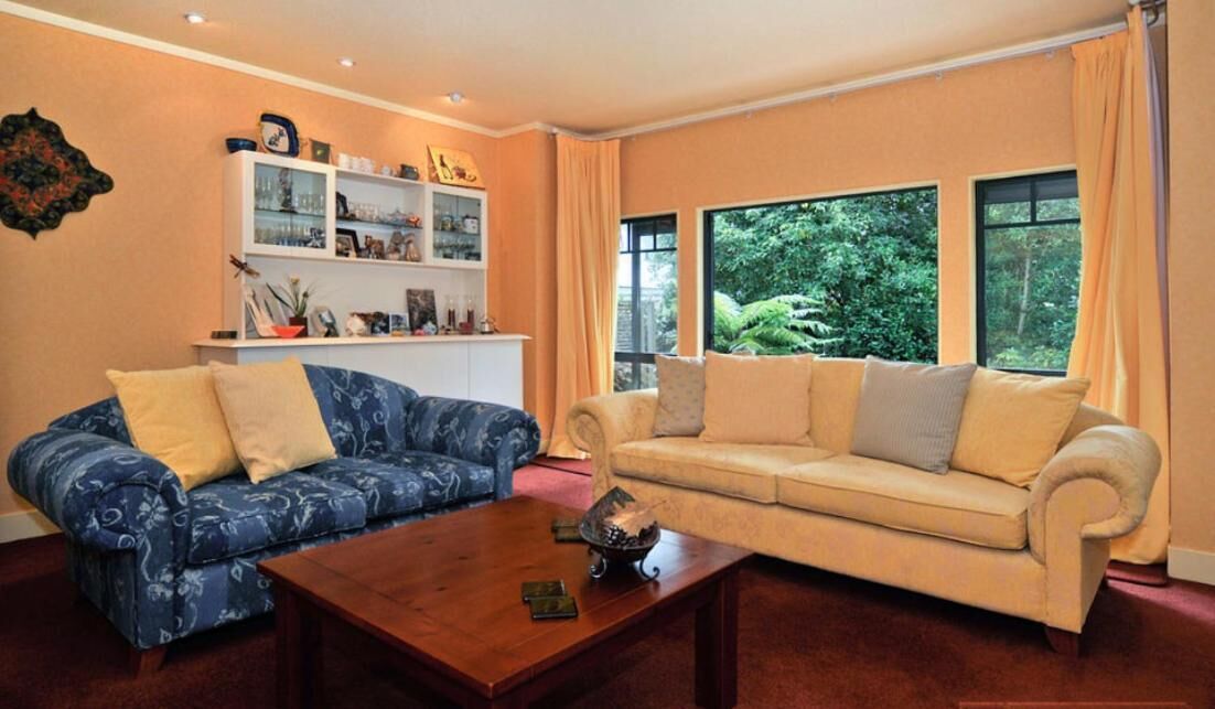 Una sala de estar con dos sofás, una mesa de centro y una estantería.