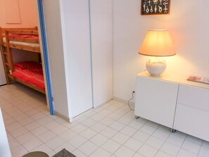 A room with a bunk bed, a white cabinet, a lamp, and a wall with key hooks. - Les Flamants Roses by Interhome (La Grande Motte)