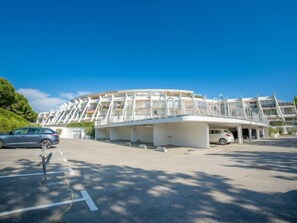 A modern building with a unique architectural design, featuring a curved structure and multiple balconies.