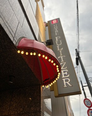 A hotel sign with a red awning and lights, and a speed limit sign of 30. - Hotel Pulitzer Jiyugaoka (Tokyo)