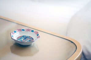 A small, decorative bowl with a colorful pattern on a glass table. - Hotel Pulitzer Jiyugaoka (Tokyo)
