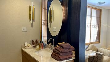 A bathroom with a large mirror, a sink, and a towel rack.