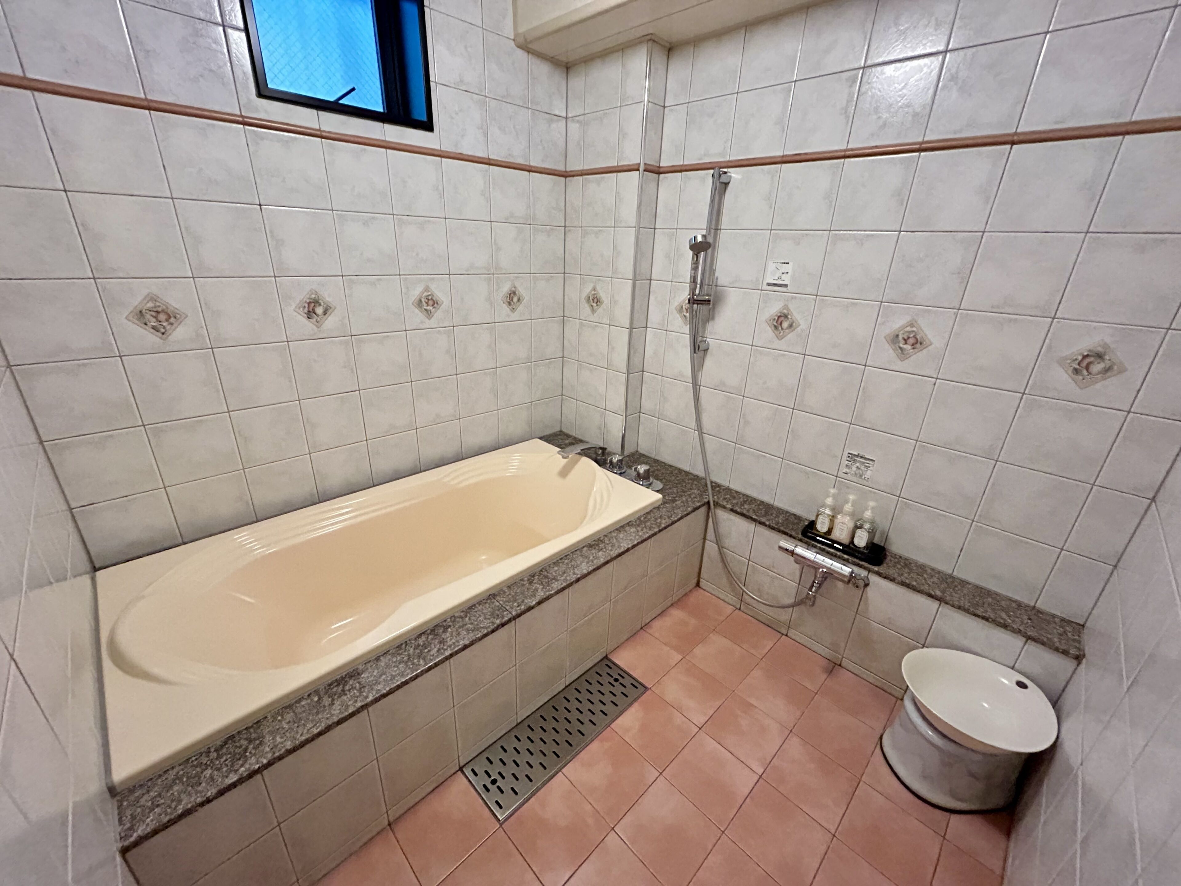 A bathroom with a bathtub, a toilet, and a shower area.