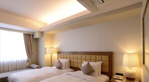 A hotel room with two beds, a large window with curtains, a wall-mounted air conditioner, and a bedside lamp. - Hotel Pulitzer Jiyugaoka (Tokyo)